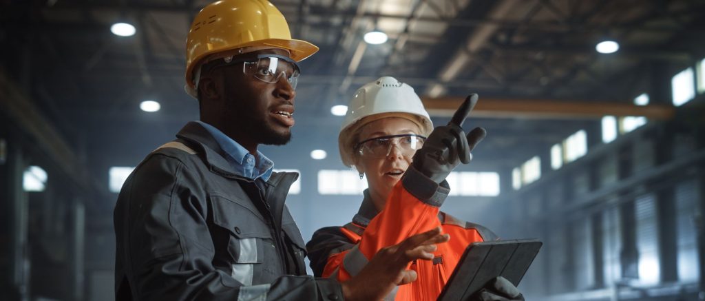 man and woman pointing wearing PPE