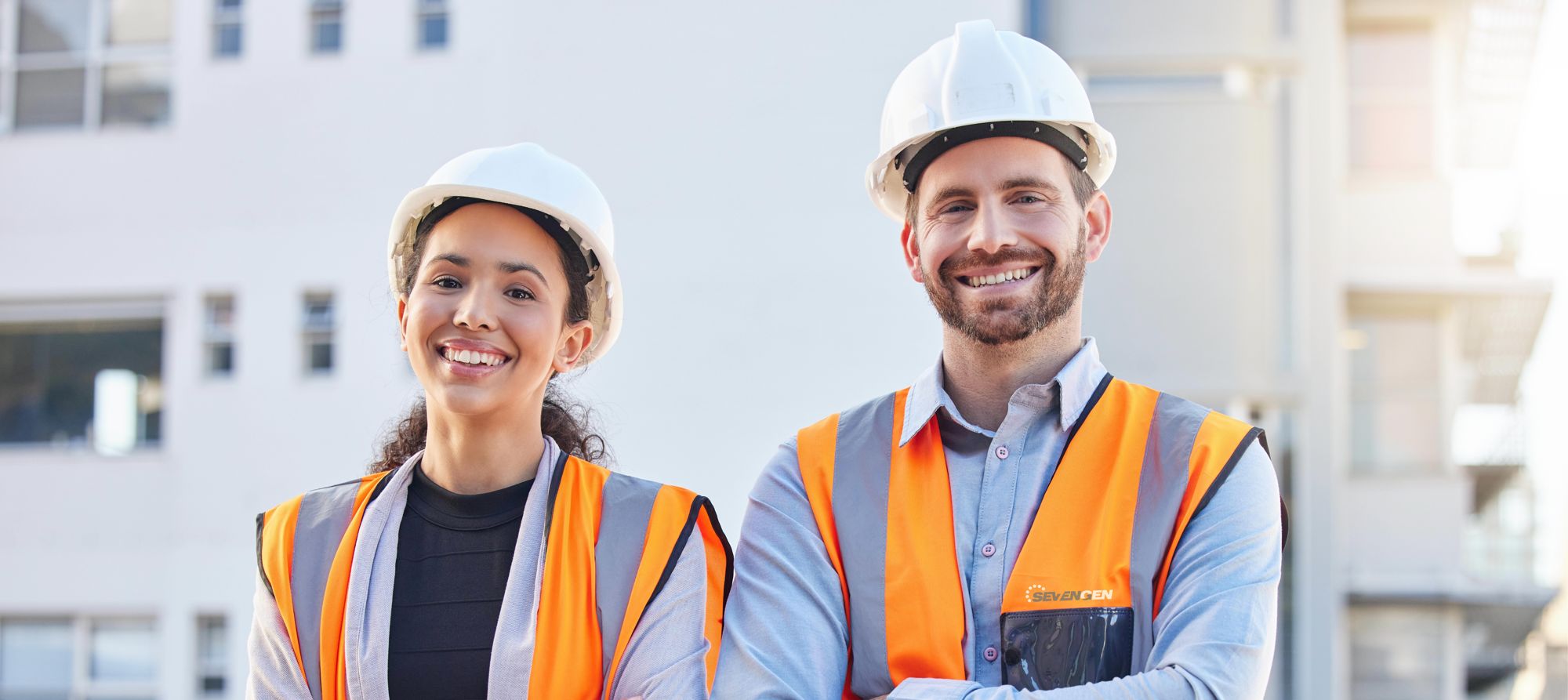 man and woman wearing hard hats and safety vests