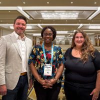 1780429334500 Three people smiling after receiving scholarship